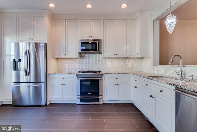 kitchen featuring light stone countertops, recessed lighting, white cabinets, stainless steel appliances, and a sink