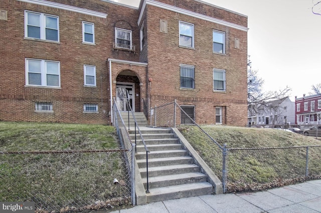 view of front of house with fence and brick siding