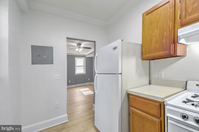 kitchen featuring crown molding, light countertops, white appliances, electric panel, and under cabinet range hood