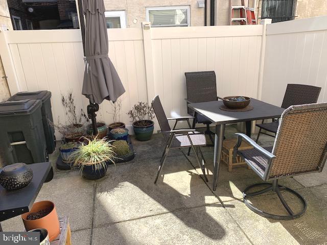 view of patio featuring outdoor dining space and fence