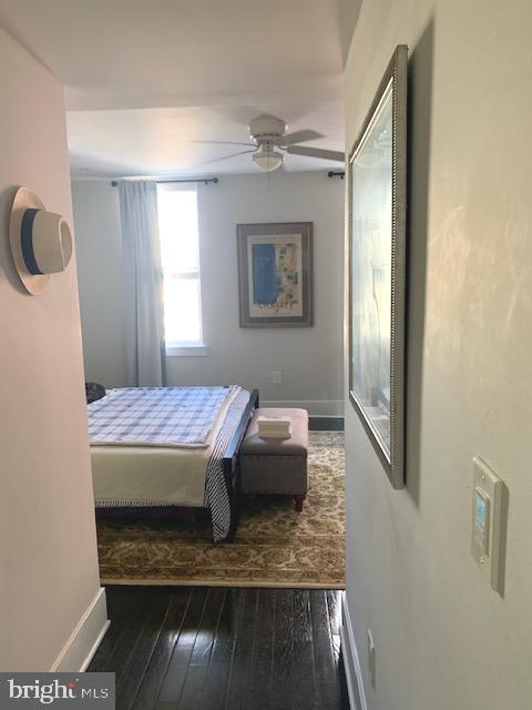 bedroom featuring hardwood / wood-style floors, baseboards, and ceiling fan