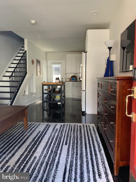 living room featuring stairway and dark wood-style floors