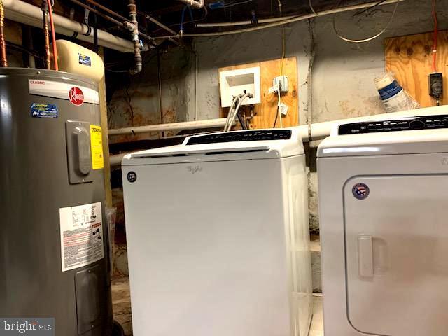 washroom with washing machine and clothes dryer, laundry area, and electric water heater