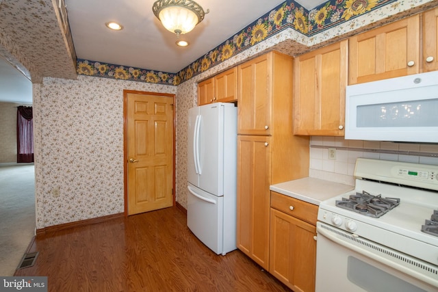 kitchen with white appliances, wood finished floors, visible vents, wallpapered walls, and light countertops