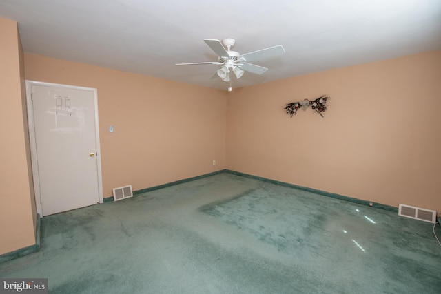 carpeted empty room with a ceiling fan, visible vents, and baseboards