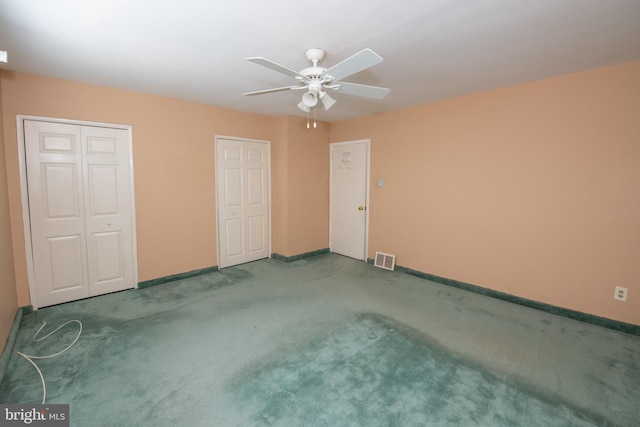 unfurnished bedroom with baseboards, visible vents, multiple closets, and carpet floors