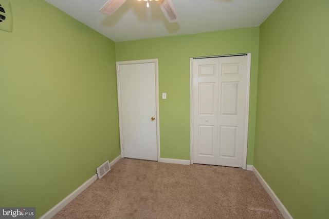 unfurnished bedroom featuring visible vents, baseboards, carpet, and a closet