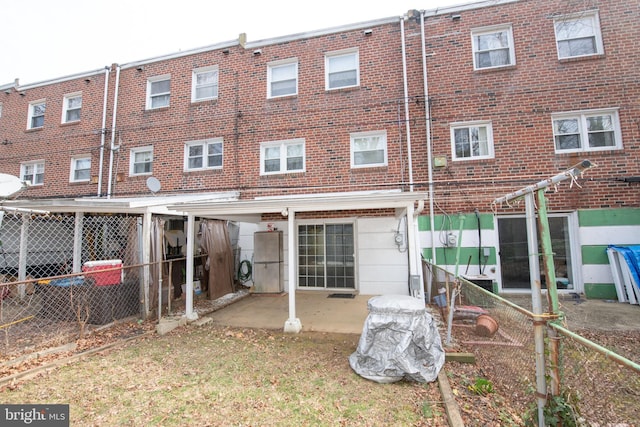 back of property with brick siding and fence