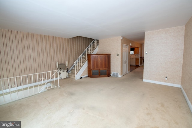 interior space featuring stairs, visible vents, baseboards, and carpet flooring