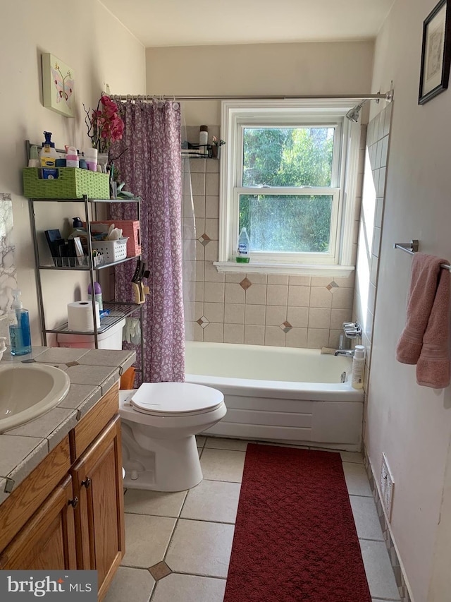 full bathroom featuring vanity, shower / bath combo with shower curtain, tile patterned flooring, and toilet