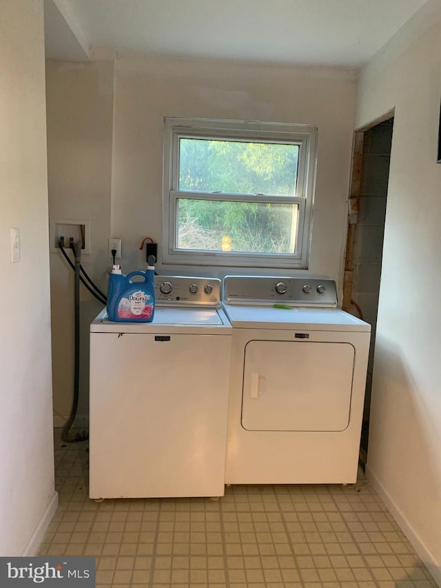 clothes washing area with laundry area, independent washer and dryer, and baseboards