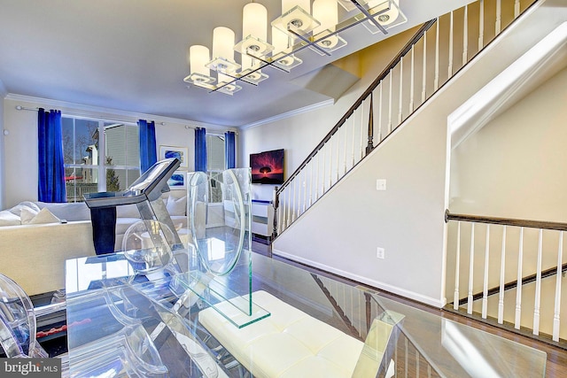 dining room featuring ornamental molding, wood finished floors, a chandelier, baseboards, and stairs