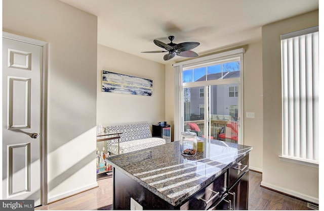 interior space featuring ceiling fan, dark wood finished floors, and baseboards