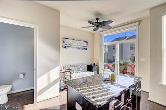 dining room featuring a ceiling fan, dark wood finished floors, and baseboards