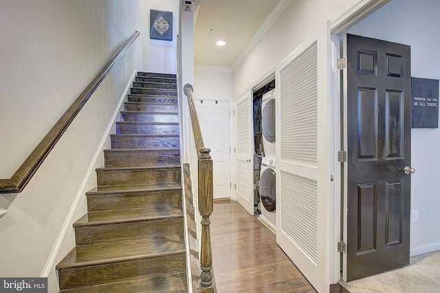 staircase featuring ornamental molding, recessed lighting, wood finished floors, and stacked washer / drying machine