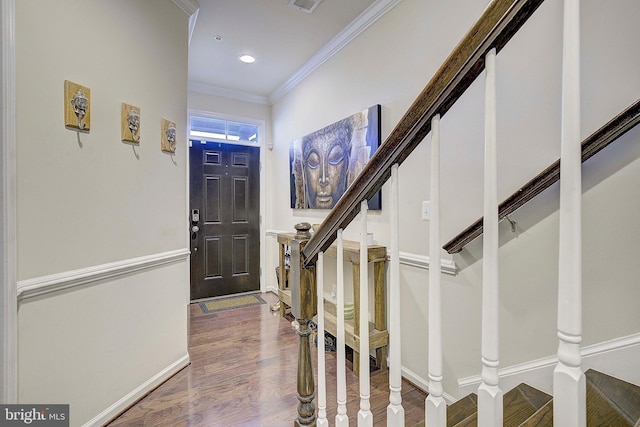 foyer entrance featuring wood finished floors, visible vents, baseboards, stairs, and ornamental molding