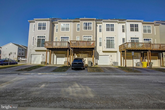 back of house featuring a garage, a residential view, and cooling unit