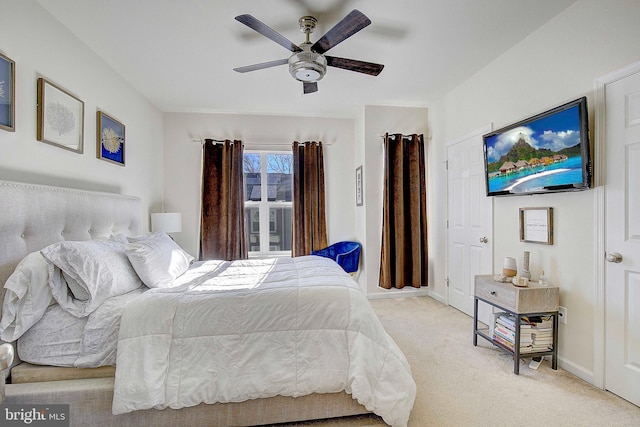 bedroom featuring light colored carpet, ceiling fan, and baseboards