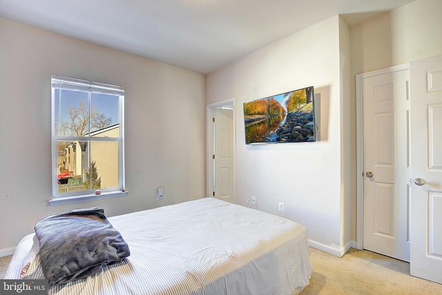 bedroom featuring light carpet and baseboards