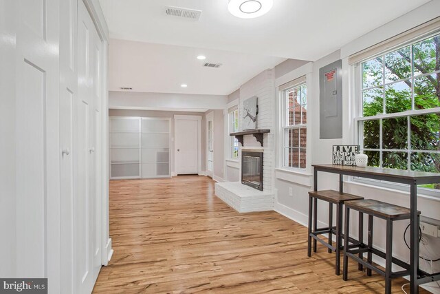 corridor featuring wood finished floors, electric panel, and recessed lighting