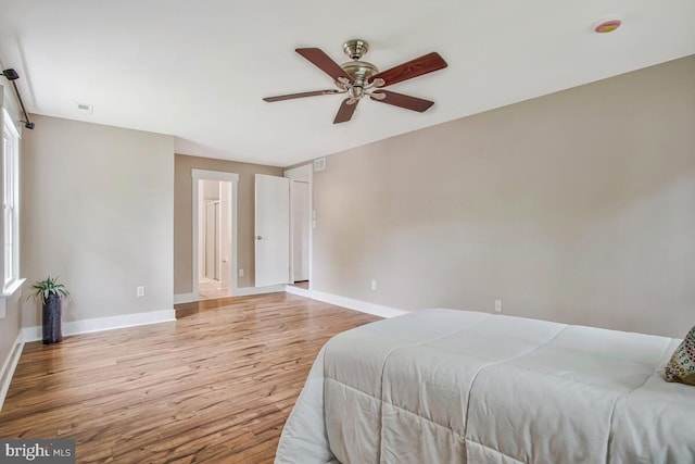 bedroom featuring light wood finished floors, baseboards, and a ceiling fan