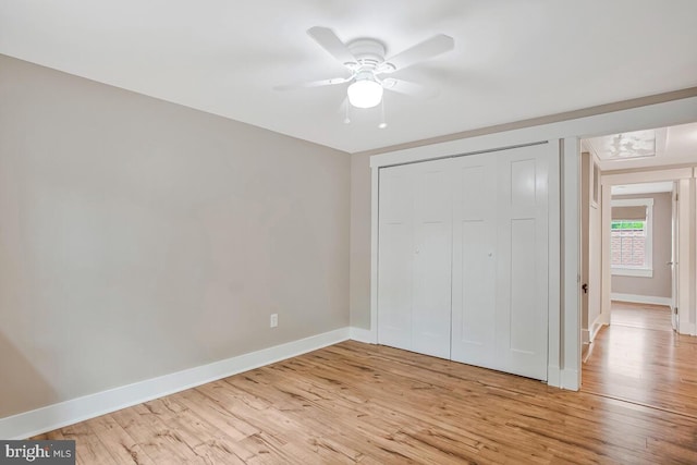 unfurnished bedroom featuring light wood finished floors, baseboards, a closet, and ceiling fan