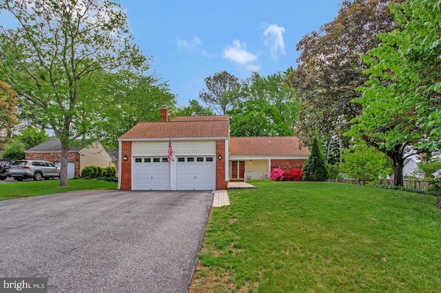 view of front facade featuring an attached garage, asphalt driveway, a chimney, and brick siding