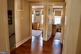 corridor with dark wood-style floors and baseboards