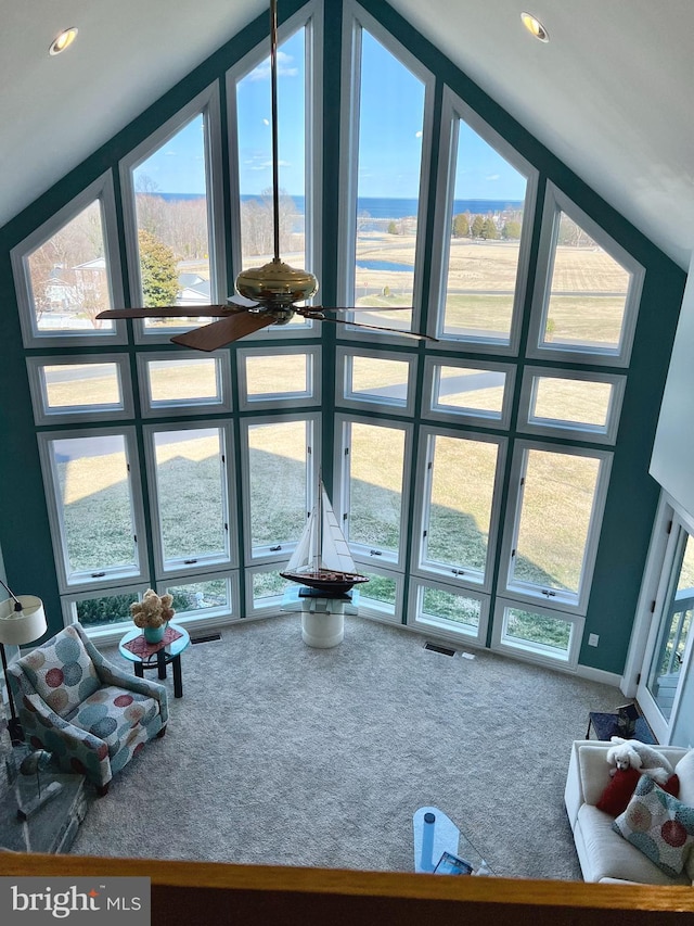 carpeted living area featuring visible vents and expansive windows