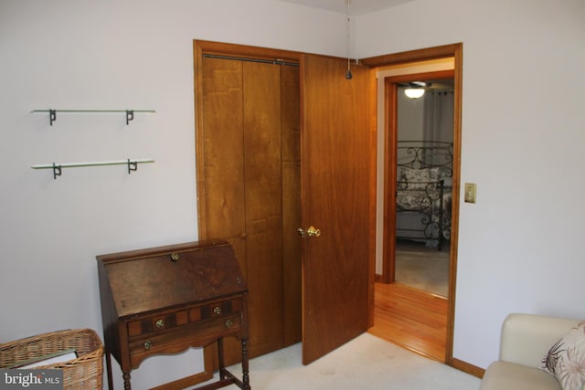 interior space with a closet, baseboards, and light colored carpet