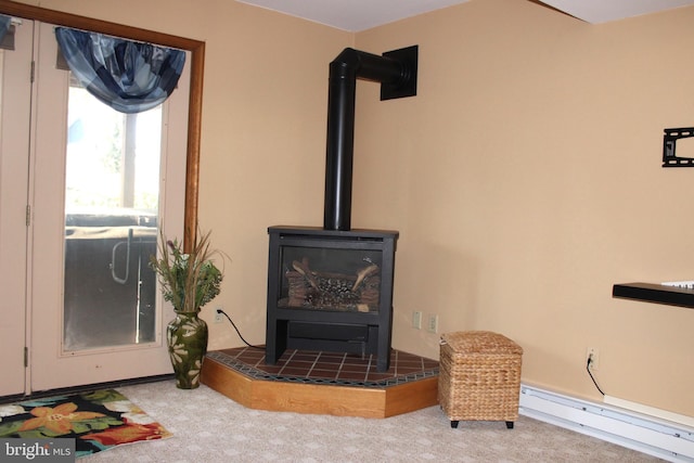 interior details with a wood stove, carpet flooring, and a baseboard radiator