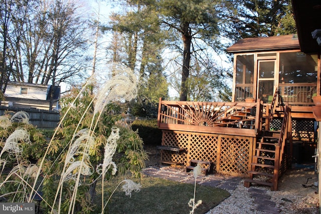 exterior space with stairway, a deck, and a sunroom