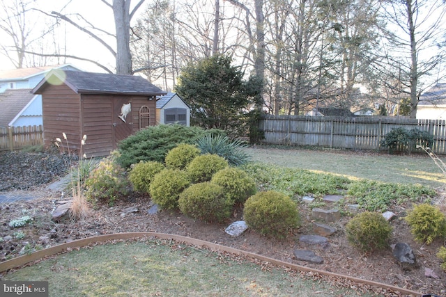 view of yard featuring a storage unit, an outbuilding, and fence