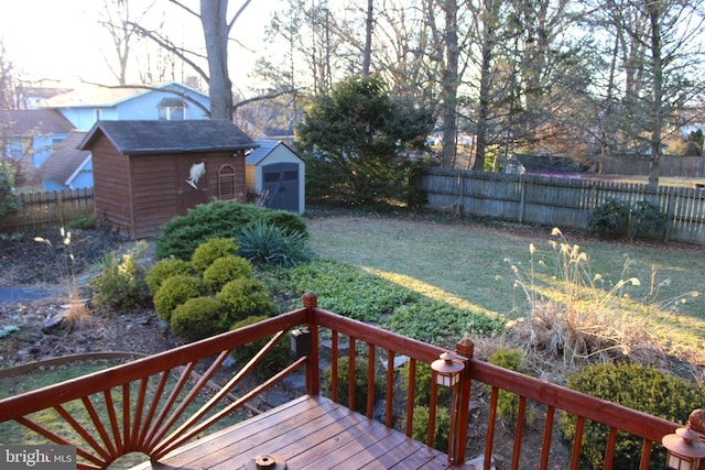 deck featuring a fenced backyard, a storage shed, and an outdoor structure