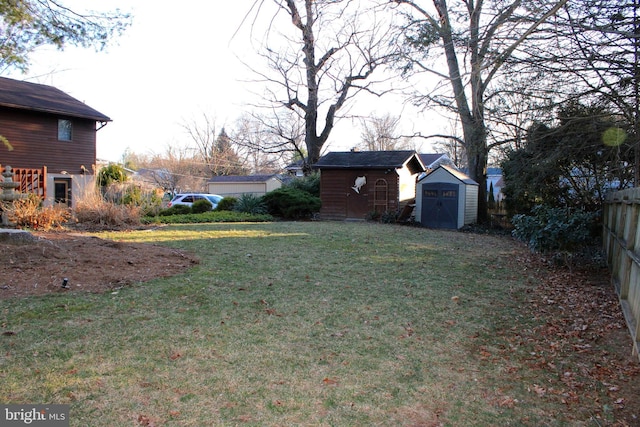 view of yard with an outdoor structure, a storage unit, and fence