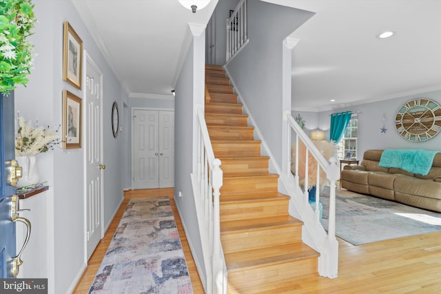 entryway with stairs, crown molding, recessed lighting, and light wood finished floors