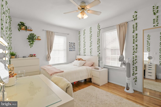 bedroom featuring baseboards, a ceiling fan, and wood finished floors