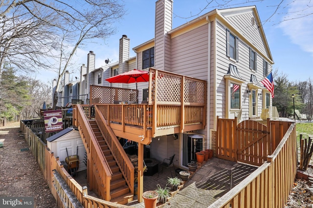 view of property exterior featuring fence, a chimney, and a wooden deck