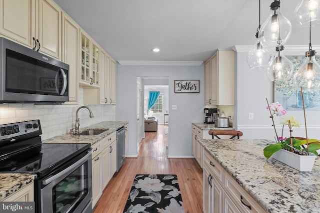 kitchen with light wood finished floors, decorative backsplash, appliances with stainless steel finishes, cream cabinetry, and a sink