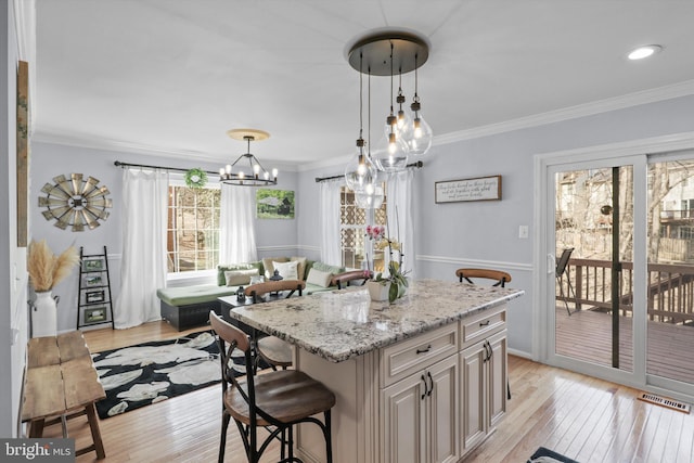 kitchen with visible vents, light wood-style floors, and crown molding