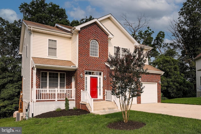 traditional-style home with brick siding, covered porch, driveway, and a front yard