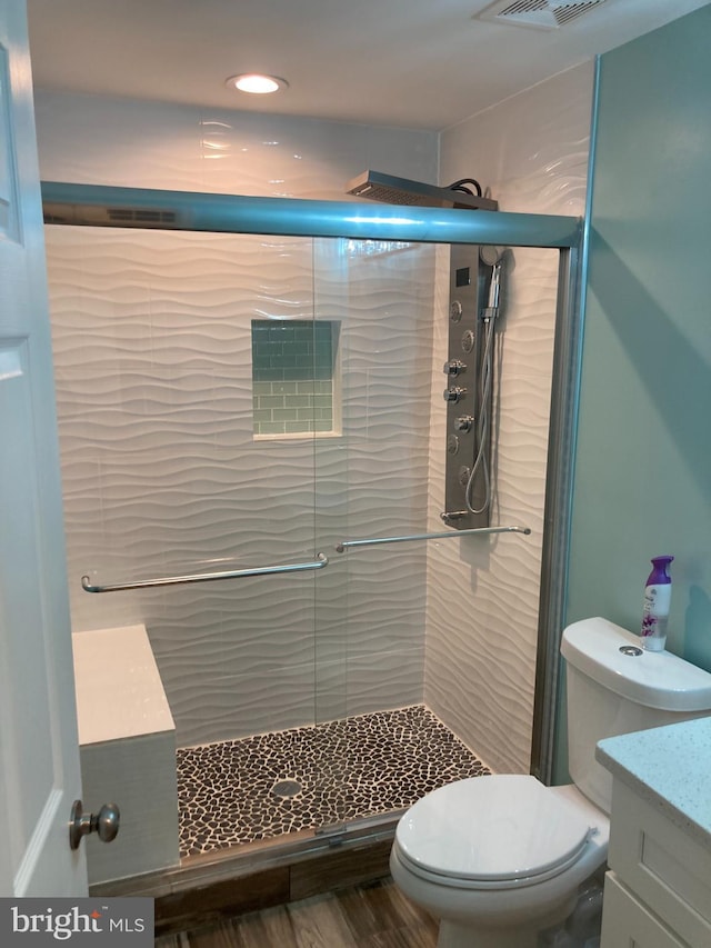 full bathroom featuring visible vents, vanity, toilet, and a shower stall