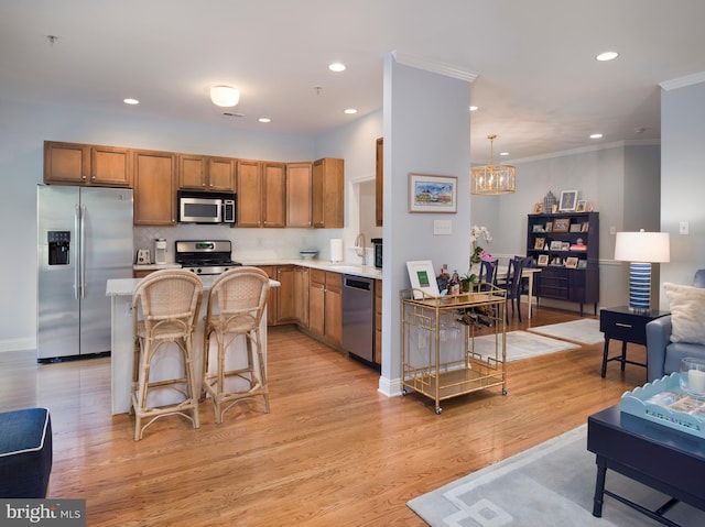 kitchen with brown cabinets, light wood-style flooring, ornamental molding, stainless steel appliances, and light countertops