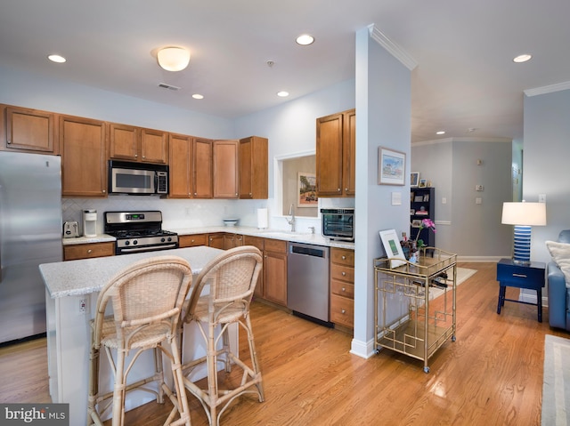 kitchen with stainless steel appliances, light wood finished floors, visible vents, and light countertops