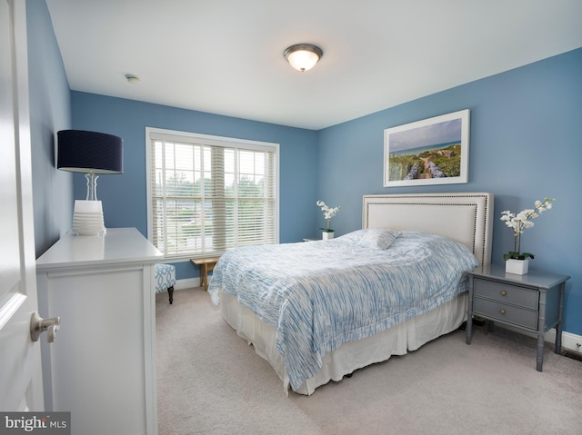 bedroom with light carpet and baseboards