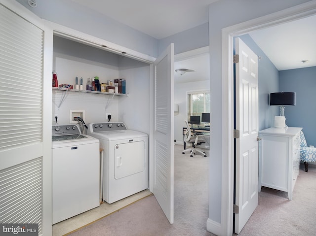 washroom featuring light carpet, separate washer and dryer, and laundry area