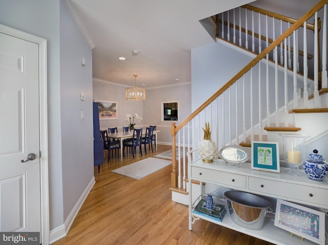 interior space featuring stairway, baseboards, ornamental molding, light wood-style floors, and a chandelier