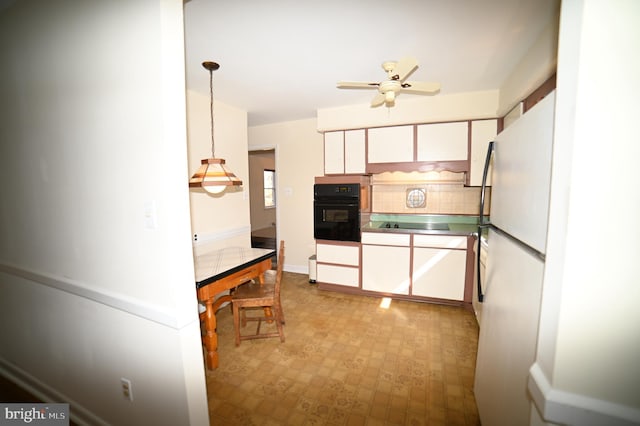 kitchen featuring freestanding refrigerator, white cabinetry, oven, and a ceiling fan