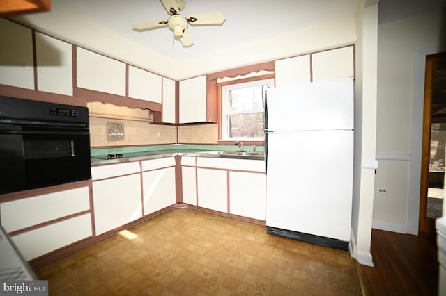 kitchen featuring a ceiling fan, a sink, black appliances, white cabinetry, and tile patterned floors