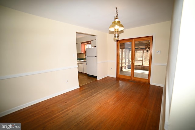 unfurnished room featuring dark wood-style floors and baseboards